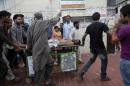 Rescue workers and relatives wheel an injured man on a stretcher, who was attacked by unknown gunmen, in Karachi