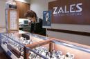 FILE - In this Jan. 4, 2007, a Zales jewelry store worker looks at watches in San Bruno, Calif. Signet Jewelers is buying Zale Corp. for approximately $690 million to help diversify its business and expand further internationally. Shares of Zale soared more than 39 percent in Wednesday, Feb. 19, 2014, premarket trading, while Signet Jewelers Ltd.' stock rose more than 9 percent. (AP Photo/Paul Sakuma, file)
