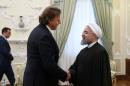 A picture released by the official website of the Iranian President Hassan Rouhani shows him (R) shaking hands with Dutch Foreign minister Bert Koenders during a meeting in the capital Tehran on September 20, 2015