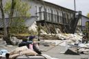 A university student takes a rest in front of their collapsed apartment caused by earthquakes in Minamiaso town, Kumamoto prefecture, southern Japan