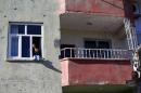 A woman and a boy look out from a bullet-riddled house in the southeastern town of Silvan in Diyarbakir province, Turkey