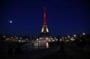 A picture taken on March 22, 2016 shows the Eiffel Tower in Paris illuminated in the colours of the Belgian flag in tribute to the victims of terrorist attacks in Brussels