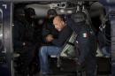 ADDS PHOTOGRAPHER'S BYLINE - Federal police escort who they identify as Servando "La Tuta" Gomez," leader of the Knights Templar cartel, as he sits inside helicopter at the Attorney General's Office hangar in Mexico City, Friday, Feb. 27, 2015. Gomez, a former school teacher who became one of Mexico's most-wanted drug lords as head of the Knights Templar cartel, was captured early Friday by federal police, according to Mexican officials. (AP Photo/Eduardo Verdugo)