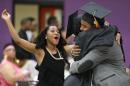 In this May 5, 2014 photo, Chanel Bowden, left, runs to join Krishaun Branch, right, and Audrey Tillis as they hug after their graduation ceremony from Fisk University in Nashville, Tenn. Branch, the former hell-raiser who'd flirted with gang life, left Urban Prep then returned to the school after a tragedy. (AP Photo/Mark Humphrey)