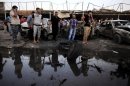 Iraqis gather at the scene of a car bomb attack at a used cars dealers parking lot in Habibiya neighborhood of eastern Baghdad, Iraq, Monday, May 27, 2013. A wave of car bombings tore through mostly Shiite Muslim neighborhoods of the Baghdad area, killing and wounding dozens of people, police said, in the latest outburst of an unusually intense wave of bloodshed roiling Iraq. The blasts are the latest indication that Iraq's security is rapidly deteriorating. (AP Photo/Karim Kadim)