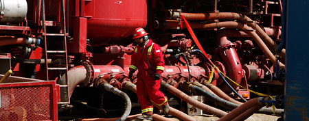 A worker steps through the maze of hoses at a remote fracking site in Rulison, Colo. (AP Photo/David Zalubowski)