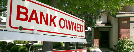 A bank owned for sale sign is posted in front of a foreclosed home.  (Photo by Justin Sullivan/Getty Images)