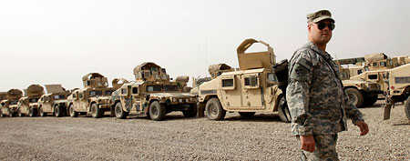 A U.S. army soldier walks past military Humvees which are ready to be shipped out of Iraq. (AP Photo/Khalid Mohammed)