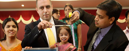Guinness World Records adjudicator Rob Molloy, center, and Dr. Manoj Pahukar of Wockhardt hospital, right, measures Jyoti Amge in Nagpur, India, Friday, Dec. 16, 2011. Amge, 18, is now eligible under the Guinness World Record guidelines for the "Shortest Woman in the world" title measuring 61.95 centimeters (2 feet). (AP Photo/Manish Swarup)