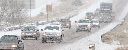 Inbound traffic on I-25 approaches Santa Fe, N.M. in a single file as snow accumulates on the road, Monday Dec. 19, 2011 as a winter storm hit the area. (AP Photo/The New Mexican, Clyde Mueller)