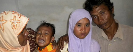 Fifteen-year-old Wati, second right, poses for a photograph with her father Yusuf, right, mother Yusniar, left, and   younger brother Aris at their home in Meulaboh, Aceh province, Indonesia, Friday, Dec. 23, 2011. (AP)