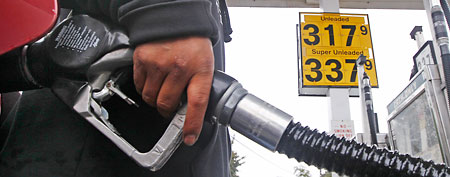 A gas station attendant fills up an automobile's tank with the gallon price of $3.17 in Wakefield, Mass., Tuesday, Oct. 4, 2011 (AP/Charles Krupa)