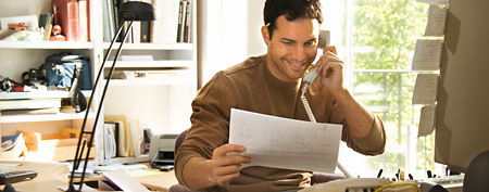 Man looking at financial documents. (ThinkStock)