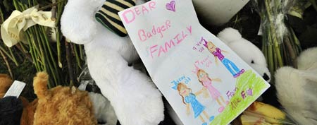 A hand-drawn card lays on top of a memorial area outside the home of Madonna Badger in Stamford, Conn., Tuesday, Dec. 27, 2011. (AP Photo/Jessica Hill)