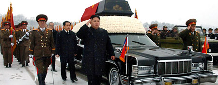 North Korea's next leader, Kim Jong Un, front center, salutes beside the hearse carrying the body of his late father and North Korean leader Kim Jong Il during the funeral procession in Pyongyang, North Korea. (AP Photo/Kyodo News)
