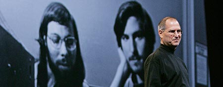 Steve Jobs, right, smiles at a 30-year-old photo of himself, right, and co-founder Steve Wozniak, left, at the MacWorld conference in San Francisco, Tuesday, Jan. 10, 2006. (AP Photo/Paul Sakuma)