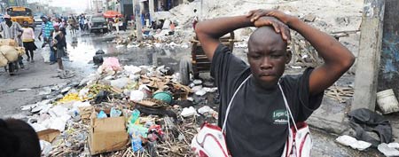 A Haitian man sells used shoes in Port-au-Prince amidst earthquake damage on January 9. (AFP/Thony Belizaire)