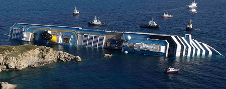 A cruise ship that ran aground is seen off the west coast of Italy at Giglio island January 14, 2012. At least three people were killed and rescuers were looking for other victims on Saturday after a large Italian cruise ship carrying more than 4,000 people ran aground overnight, took on water and tipped over. (REUTERS Photo)/Remo Casilli)