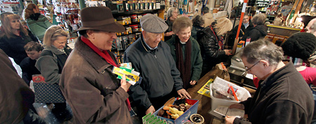Jack Shutts, front right, works the counter as throngs of people wait to make their purchases at Chagrin Hardware in Chagrin Falls, Ohio. (AP Photo/Amy Sancetta)