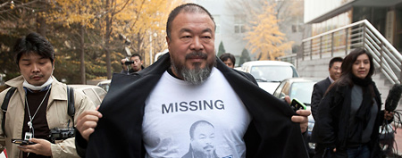 Chinese dissident artist Ai Weiwei opens his jacket to reveal a shirt bearing his portrait as he walks into the Beijing Local Taxation Bureau in Beijing. The outspoken artist said Friday, Jan. 6, 2012, that Beijing tax authorities have agreed to review their ruling that he pay a multimillion dollar fine for alleged tax evasion. (AP Photo/Andy Wong, File)