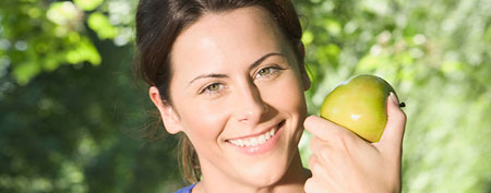 Woman eating apple. (Jupiterimages)