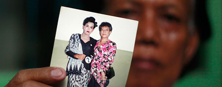 Evie, also known as Turdi, the former nanny of U.S. President Barack Obama, shows a picture of herself, left, dressed as a woman with an unidentified friend in a pageant (AP/Dita Alangkara)