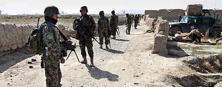 Soldiers stand on alert near the site where militants opened fire on a delegation of senior Afghan officials in Panjwai. (AP/Allauddin Khan)