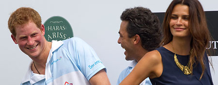 Britain's Prince Harry, left, smiles after greeting Brazil's model Fernanda Motta, right. (AP/Andre Penner)