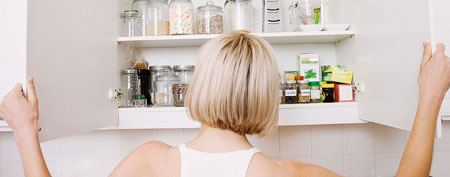 Woman opens food cabinet (ThinkStock)