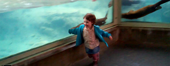 Little girl races otters (Screen)
