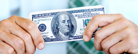 Man holding hundred-dollar bill (Thinkstock)