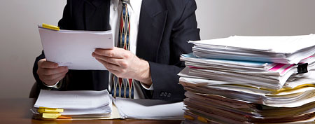Manager with pile of resumes (Thinkstock)