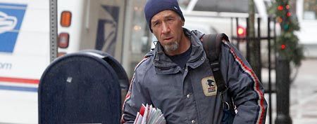 Mail carrier Mike Gillis delvers mail Tuesday, Dec. 6, 2011 in Montpelier, Vt. (AP Photo/Toby Talbot)
