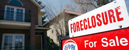A foreclosure sign sits atop a sale sign in front of a single-family home in Denver on Sunday, April 4, 2010. (AP Photo/David Zalubowski, File)