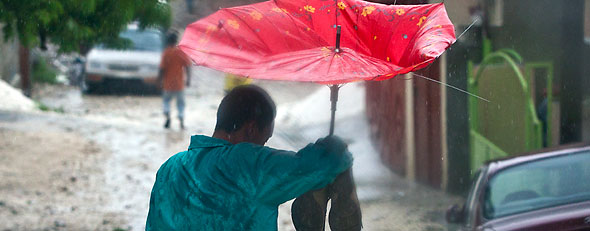 A man tries to stay dry in Port au Prince, Haiti, amidst floodwaters from Tropical Storm Isaac, Saturday, Aug. 25, 2012. (AP Photo/The Miami Herald, Patrick Farrell)
