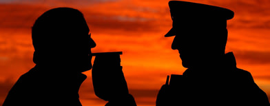 Silhouette of a police officer breathalysing a man (PA)