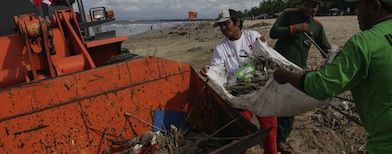 Petugas kebersihan mengumpulkan sampah ke alat berat untuk dibuang dari Pantai Kuta, Bali. Foto: Tempo/Johannes P Christo